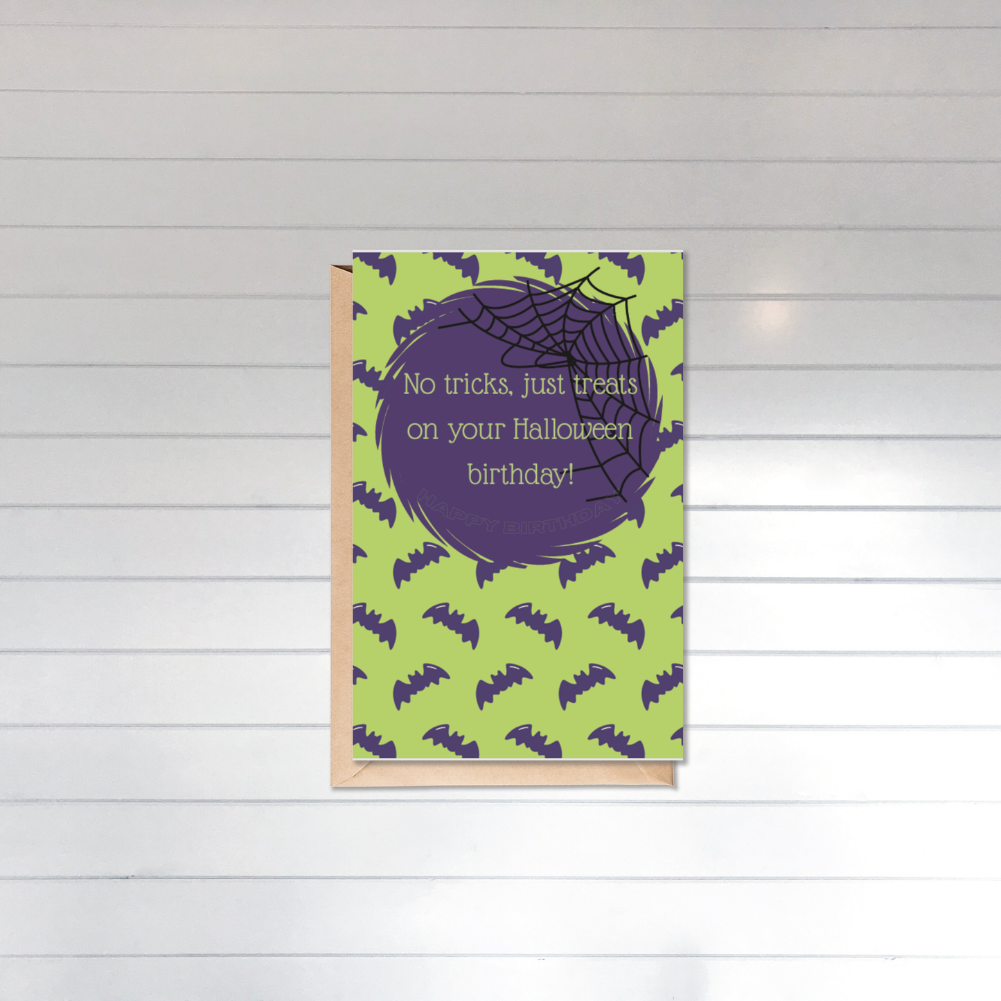 Halloween-themed birthday card with green background and purple text on a white wooden surface