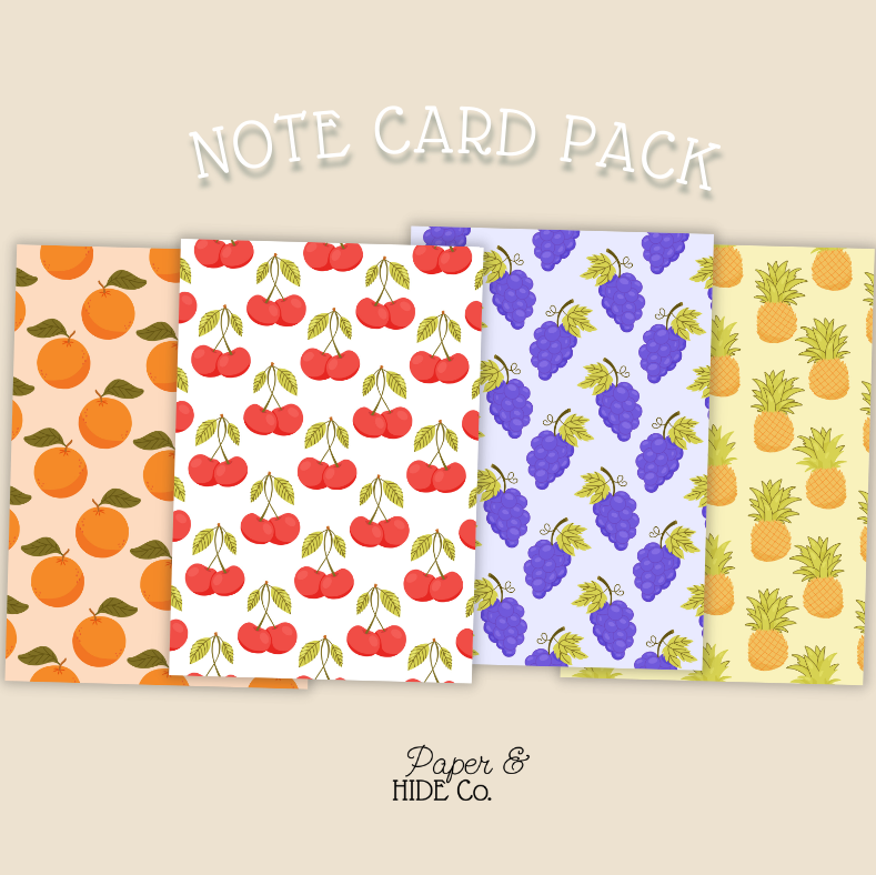 Note card pack with fruit patterns on a beige background, featuring oranges, cherries, grapes, and pineapples.