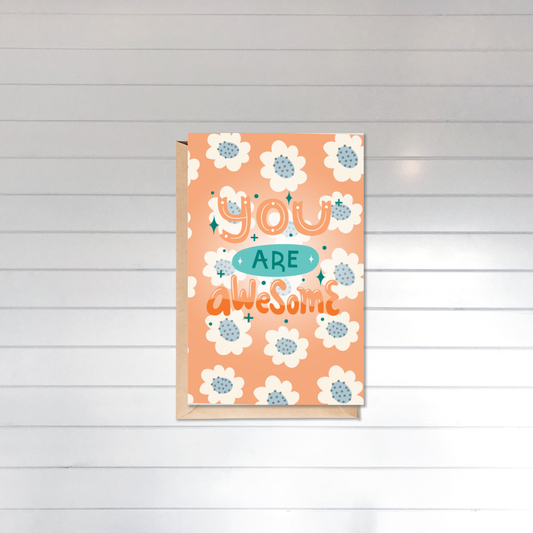 Card with floral design and 'You are awesome' text on a wooden background